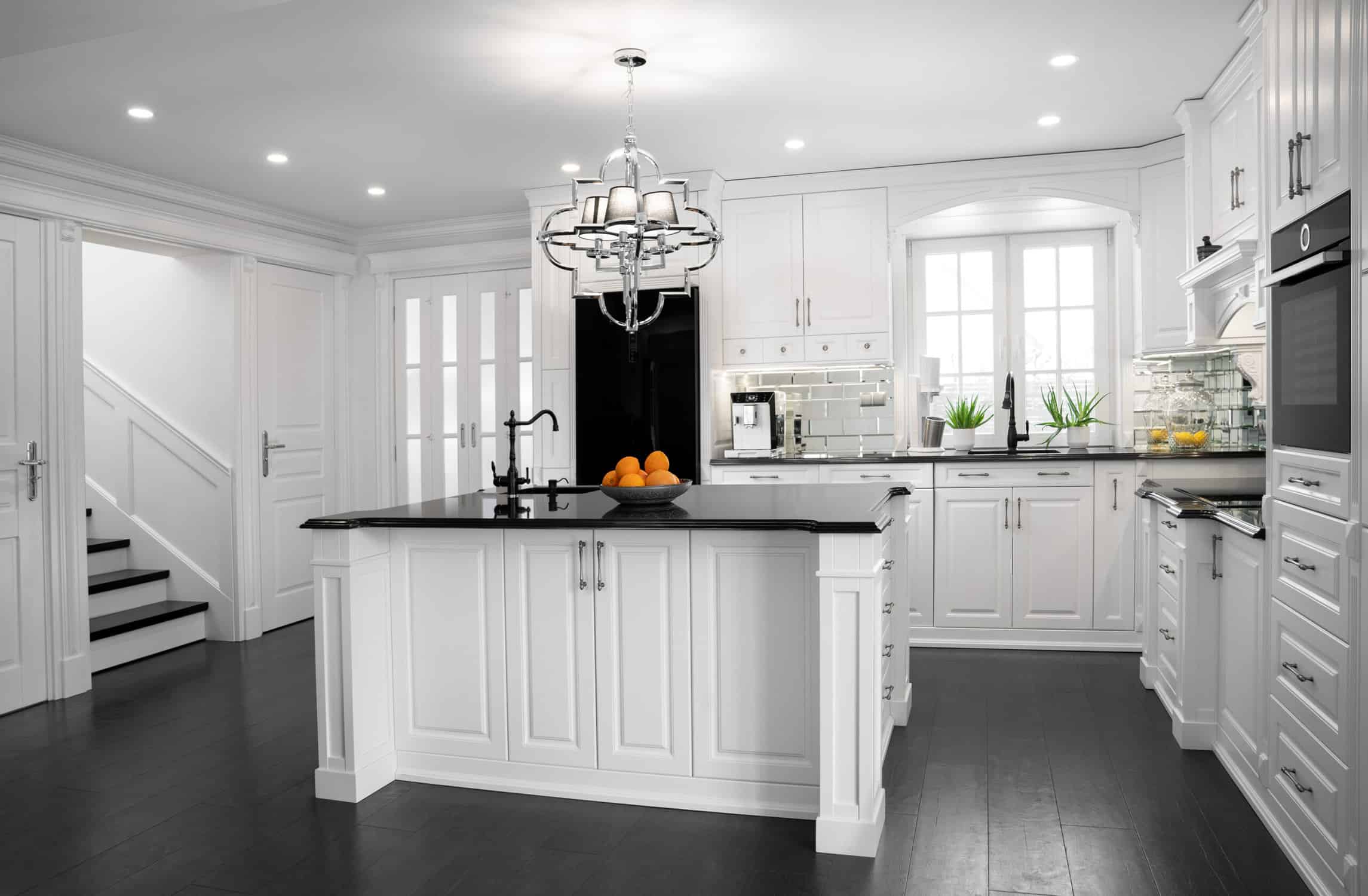 Cream White Kitchen Cabinets Cream-white painted kitchen cabinets with black hardware, black granite countertop island, and recessed ceiling lights in
