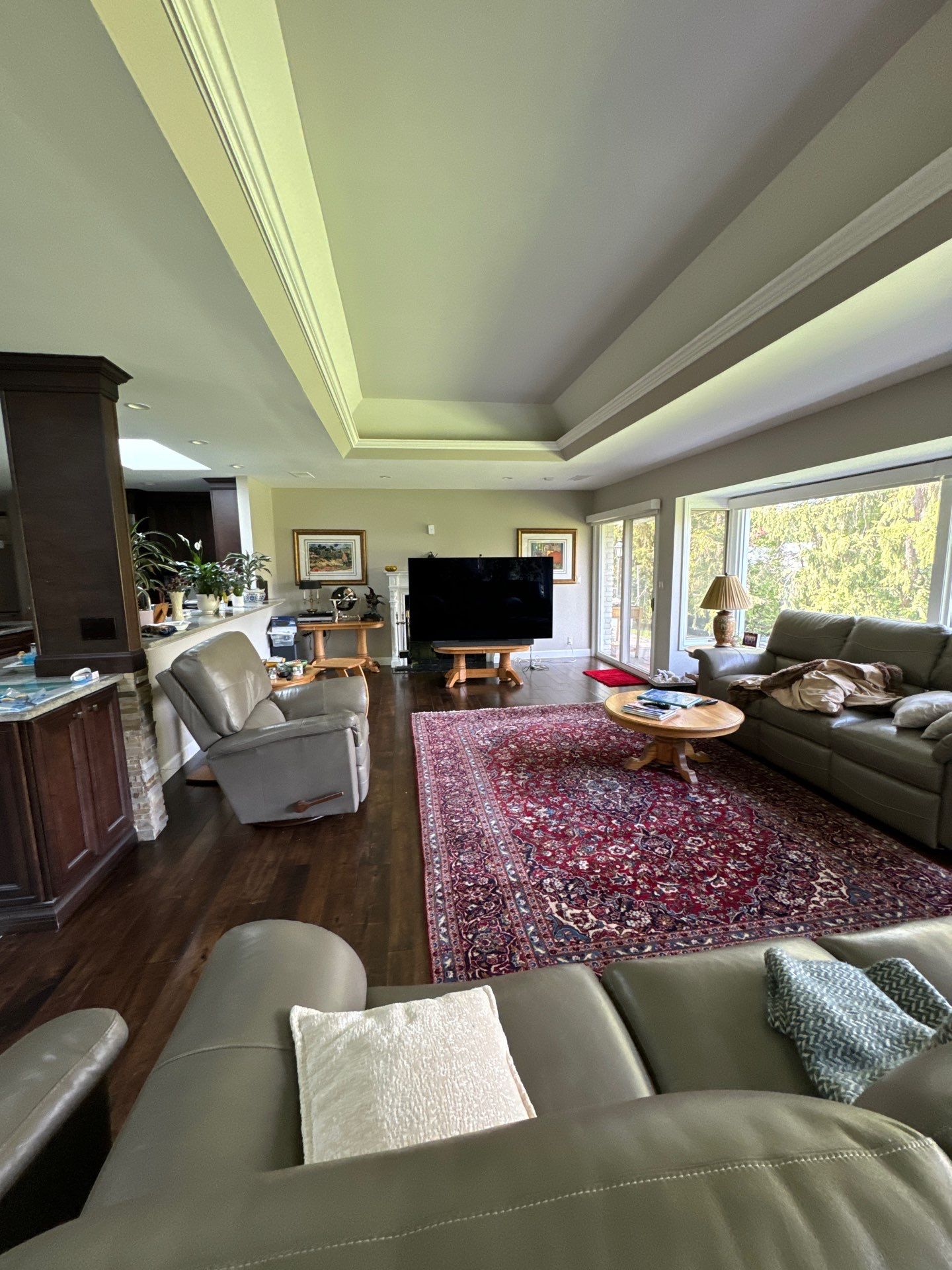 Spacious Living Room Interior Painting with Neutral Walls A comfortable and spacious living room featuring freshly painted neutral walls and dark hardwood floors.