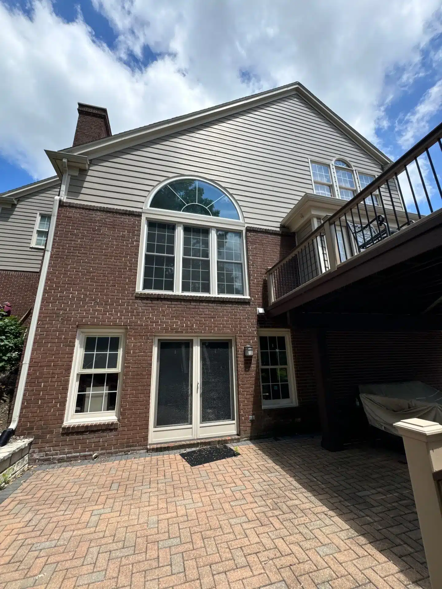 Residential Home Exterior Painting Light gray and cream-white painted horizontal siding and trim on red brick two-story residential home in Bloomfield, MI